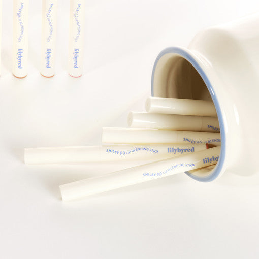 Lilybyred Smiley Lip Blending Stick 0.8g pencils displayed in a ceramic jar, highlighting sleek white packaging with blue branding.