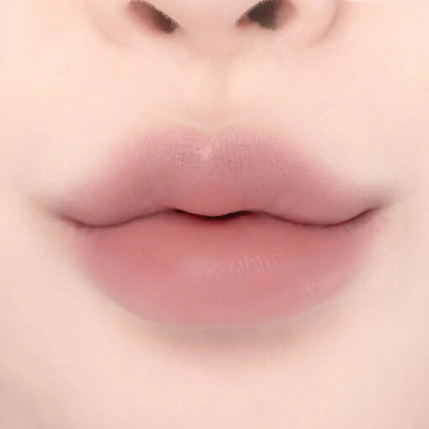 Close-up of lips wearing Lilybyred Smiley Lip Blending Stick 0.8g in a soft mauve shade, showing smooth matte finish and defined shape.
