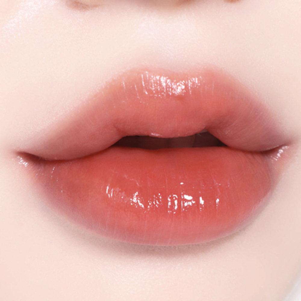 Close-up of lips wearing BBIA L'eau Tint 4.5g in a warm peach shade, highlighting its glossy, hydrating finish and natural tint effect.