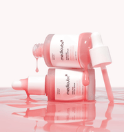 Pink-toned serum captured mid-drop, emphasizing skin-rejuvenating ingredients and texture clarity.