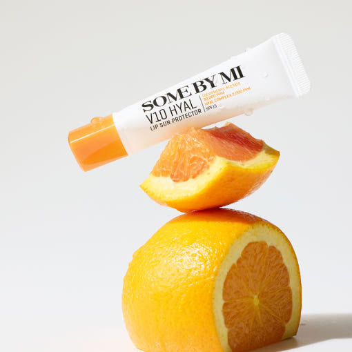 SOME BY MI V10 Hyal Lip Sun Protector 7ml orange variant displayed with fresh orange slices, emphasizing its citrus-infused hydration and SPF care.