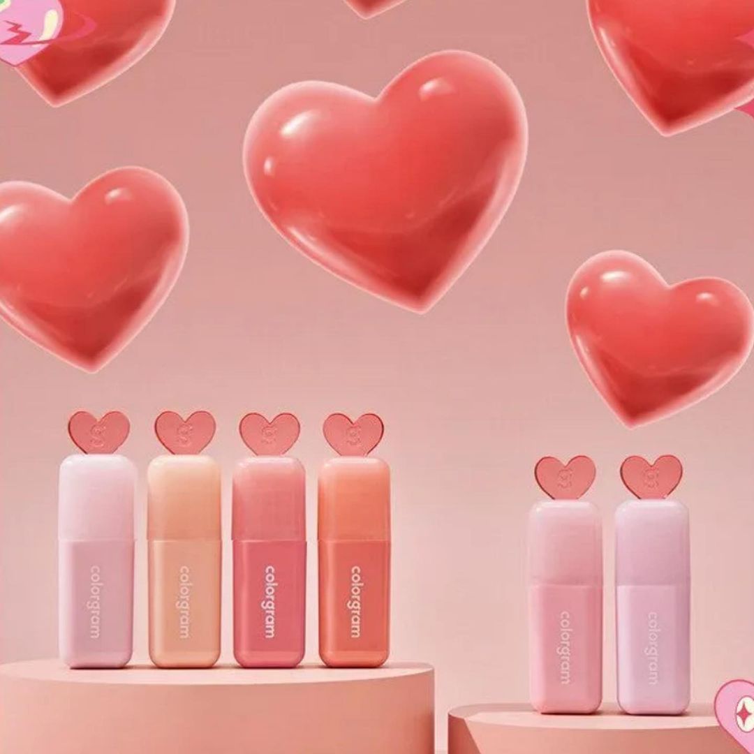 Colorgram Juicy Drop Tint 4g lip tints displayed with floating heart graphics, showcasing soft pastel packaging in pink and peach tones.