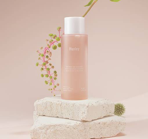 Huxley Perfume Hair Essence 80ml #Moroccan Gardener displayed on stone blocks with floral accents, highlighting its botanical and premium appeal.