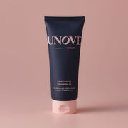 UNOVE Deep Damage Treatment EX 207ml conditioner balanced on glossy pink fingers, showcasing premium keratin hair repair formula.